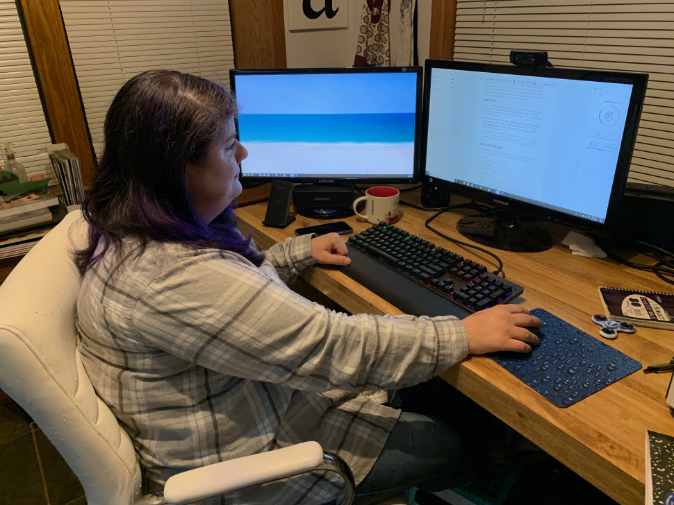 A woman sitting at a desk writing something in INK. 