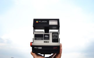 A polaroid Camera Holding in Hand