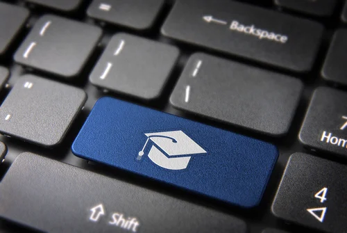 Graduation cap on a button that is part of a keyboard.